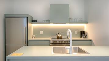 Une cuisine moderne équipée d’un réfrigérateur en acier inoxydable, d’une cuisinière à gaz et d’un évier.