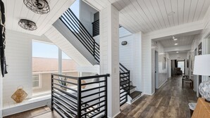 A spacious interior with a staircase, wooden flooring, and a view to the outside.