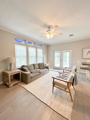 Relax in this spacious living room with a sofa, coffee table, and dining area, perfect for unwinding and enjoying the view.
