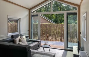 A modern living room with a large sliding glass door leading to a patio area. - Stunning home in Putten with kitchen (Putten)