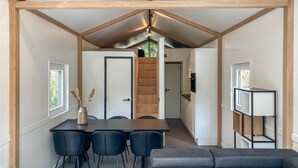A modern interior with a dining area, a staircase, and a kitchen.