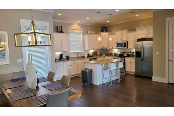 A spacious kitchen with white cabinets, a large island, and modern appliances.