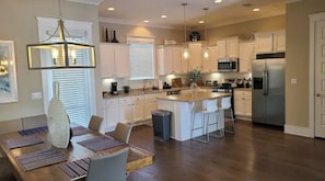 A spacious kitchen with white cabinets, a large island, and modern appliances. - Beautiful 3 Bedroom Beach Home in Santa Rosa Beach on 30A (Santa Rosa Beach)