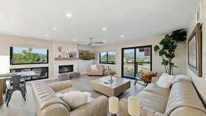 Un salón amplio con chimenea, ventanas grandes y vistas al exterior.