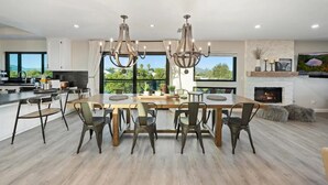 Una cocina moderna con una isla grande, iluminación colgante y vistas al exterior.