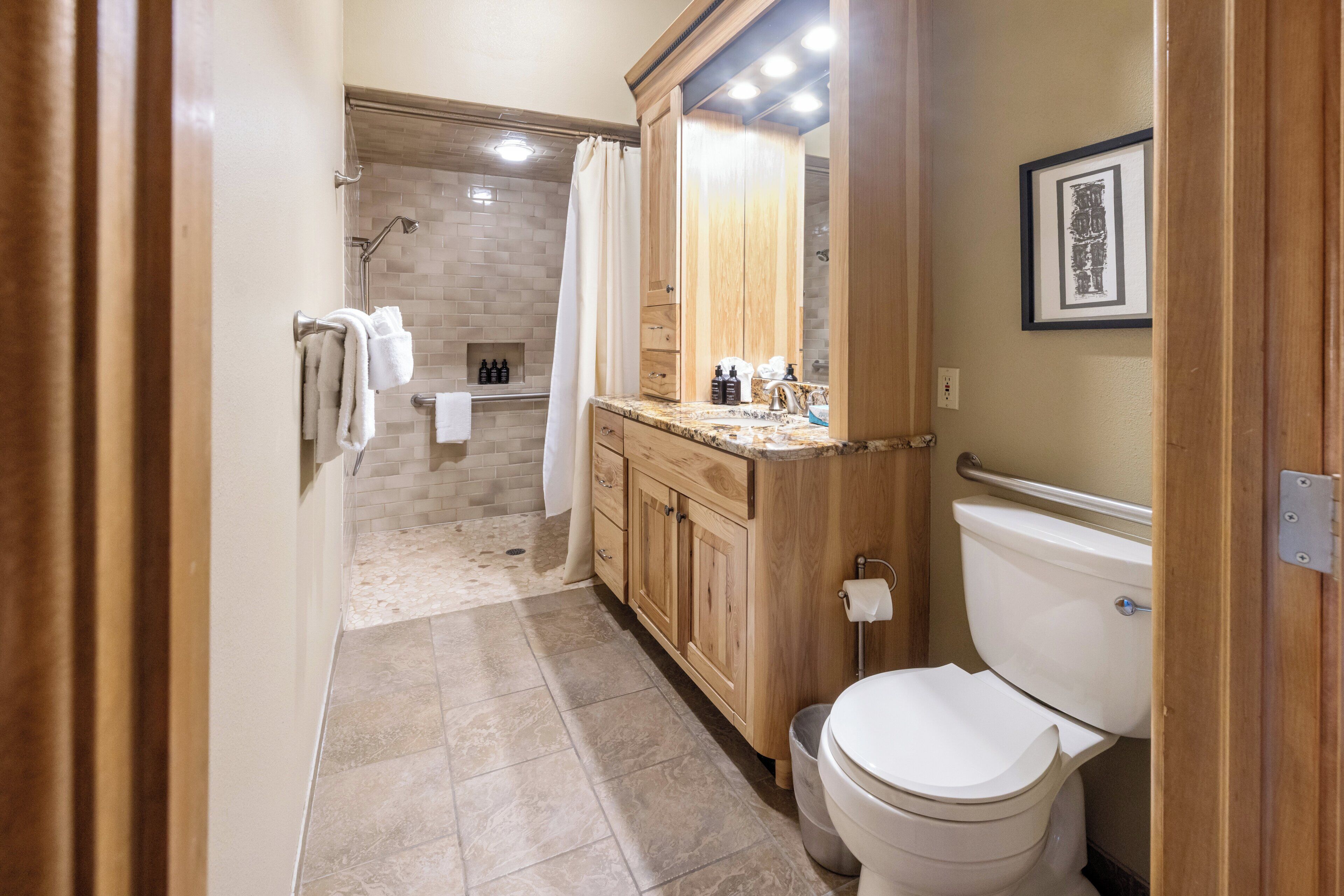 Une salle de bain moderne équipée d’une douche, de toilettes et d’un meuble-lavabo.