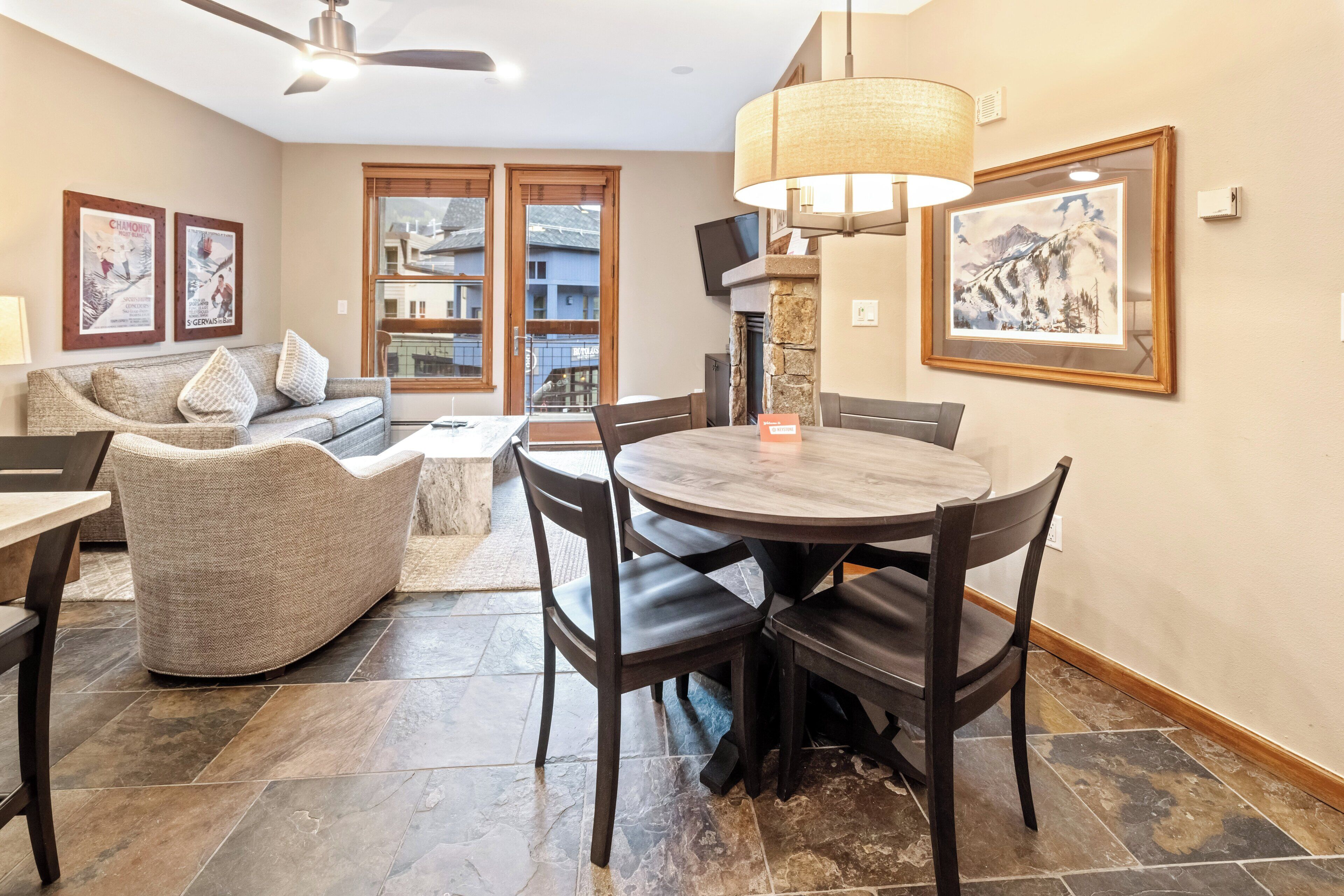 A dining area with a round table and chairs, a sofa, and a fireplace.