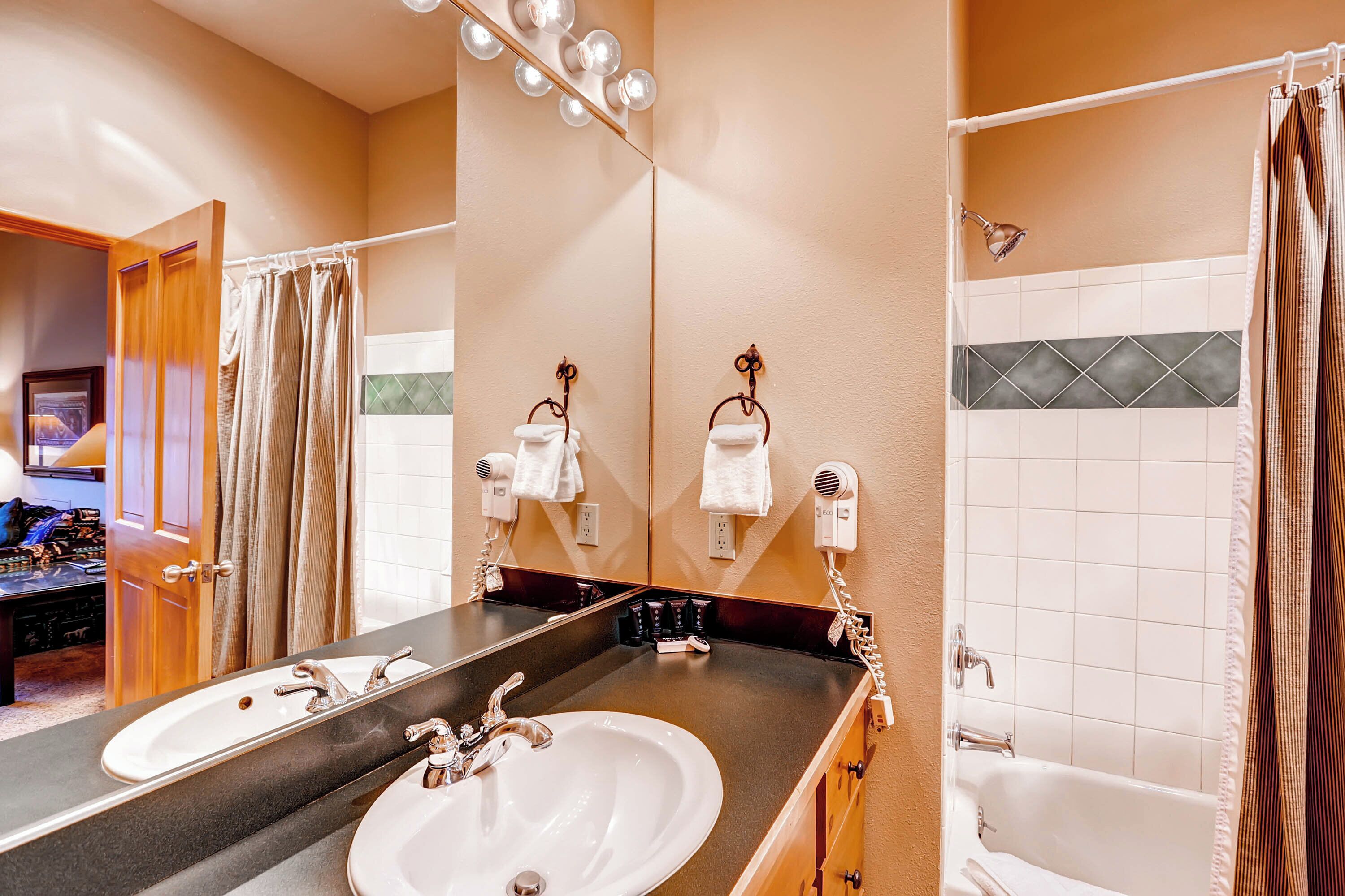 A bathroom with two sinks, a large mirror, and a shower.