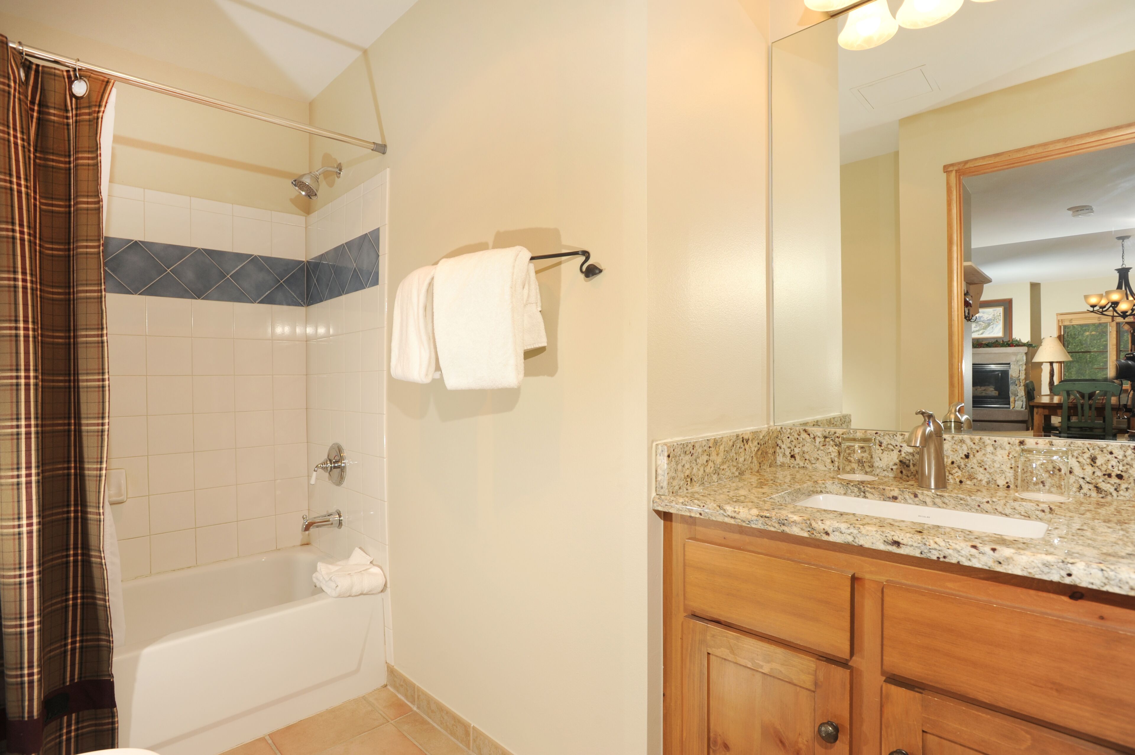 A bathroom with a bathtub, a shower, a sink, and a mirror.