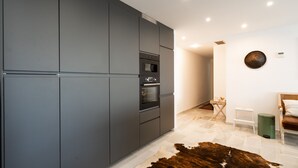 Una cocina moderna con armarios grises, electrodomésticos integrados y un tapete de piel de vaca.