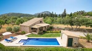A stone house with a swimming pool, outdoor seating, and a view of the surrounding landscape. - Attractive, Spacious Villa for Couples, A/C, Private Pool, Rural Views, Walking Distance to Pollenca (Pollença)