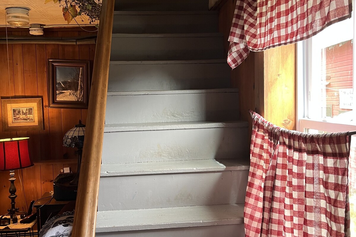 A staircase with a checkered curtain and a lamp on the left.