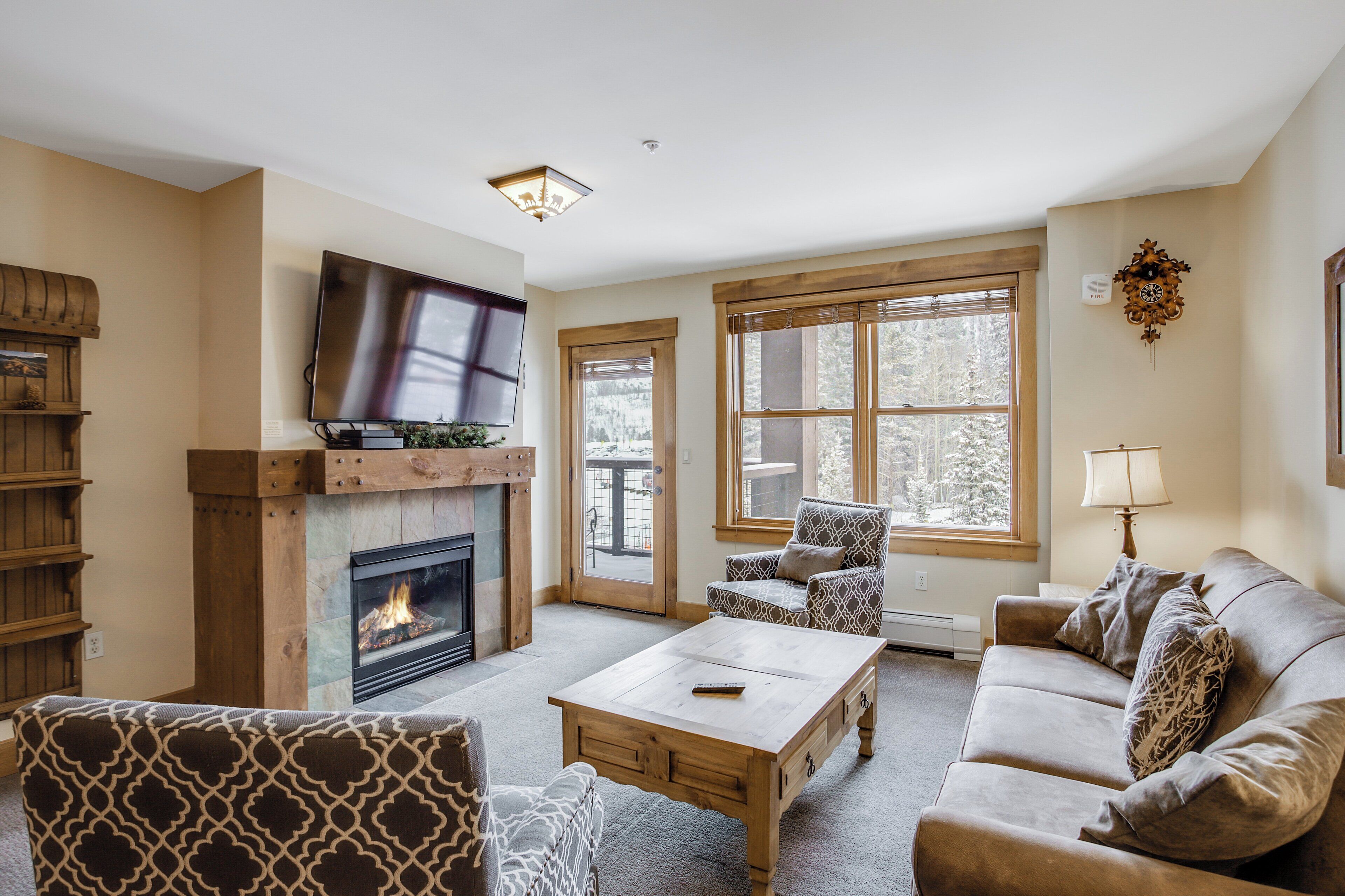 A living room with a fireplace, a sofa, a coffee table, and a television.