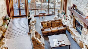 A cozy lobby with a leather sofa, a wooden coffee table, and a fireplace.