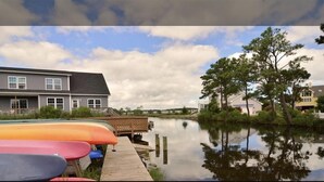 A lakeside property with a dock and canoes, surrounded by houses and trees. - Family Friendly Townhome in desired Stewards Watch Community- 5mins to the beach (Bethany Beach)
