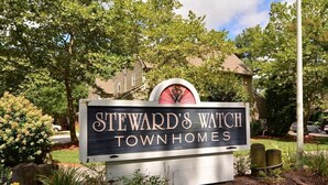 A sign for 'Steward's Watch Town Homes' with a logo above the text. - Family Friendly Townhome in desired Stewards Watch Community- 5mins to the beach (Bethany Beach)