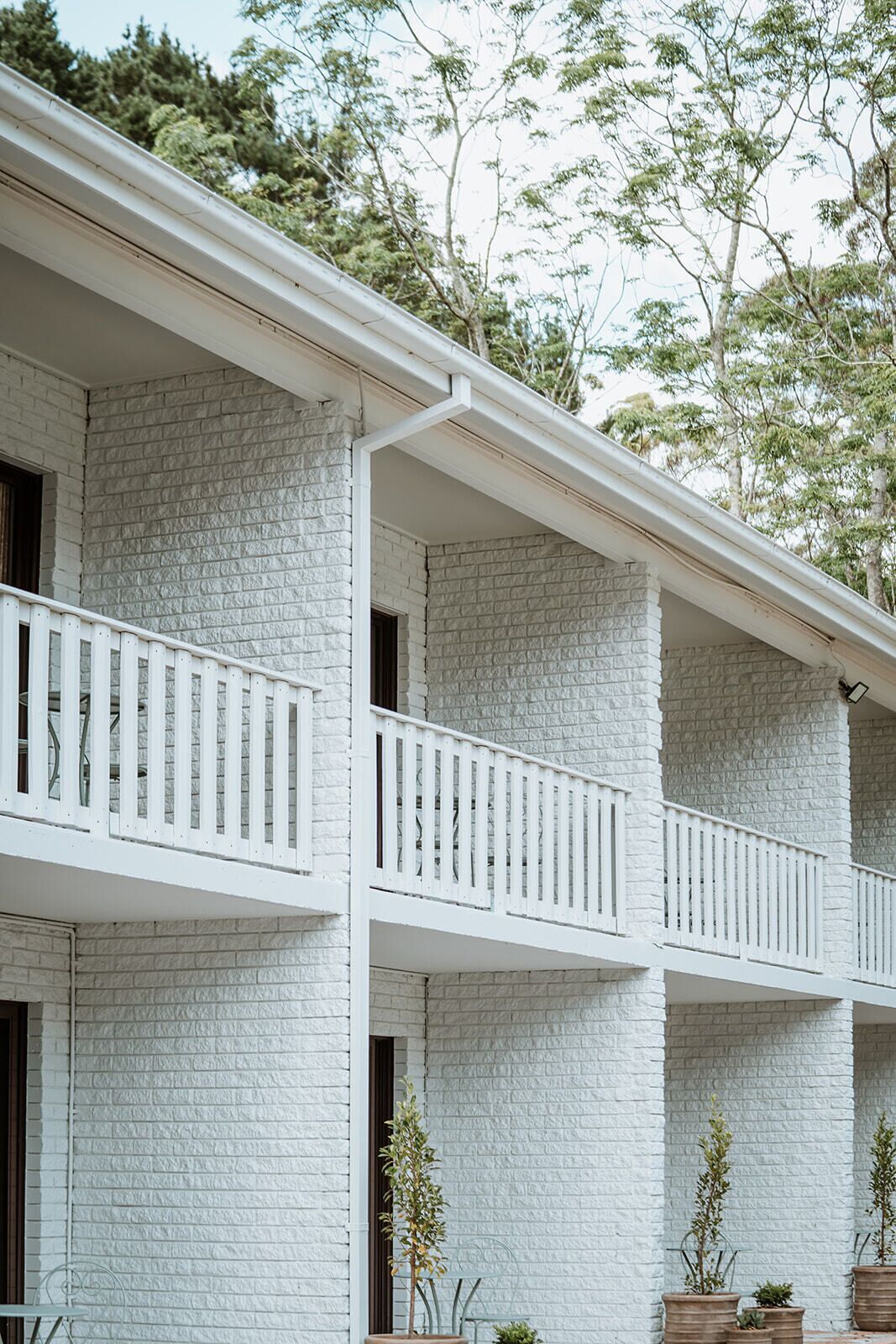 A multi-story building with white brick walls and white railings on balconies.