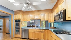 Una cocina moderna con armarios de madera, electrodomésticos de acero inoxidable y una isla grande.