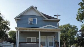 A two-story house with a front porch, a garage, and a driveway.