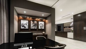 Een moderne hotellobby met een receptiebalie, een computerinrichting en kunst aan de muur.