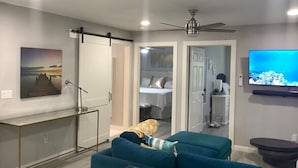 A modern living room with a sofa, a TV, and a ceiling fan. - Flawless Faith (Redding)