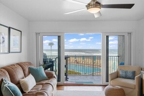Un salon avec vue sur la plage et l’océan, grâce à de grandes portes coulissantes.