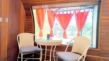 Una habitación acogedora con dos sillones de mimbre y una pequeña mesa de vidrio.