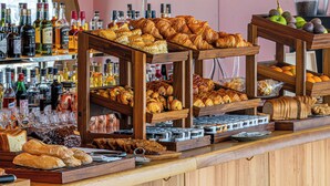 A bar area with shelves of various liquor bottles and a display of pastries and bread. - Too Hotel & Spa Paris - MGallery Collection (Paris)