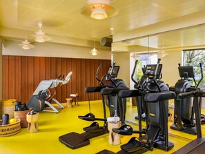 A gym with exercise equipment, a wooden wall, and a yellow floor. - Too Hotel & Spa Paris - MGallery Collection (Paris)