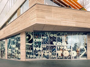 A modern building facade with large windows displaying various patterns and text. - Too Hotel & Spa Paris - MGallery Collection (Paris)