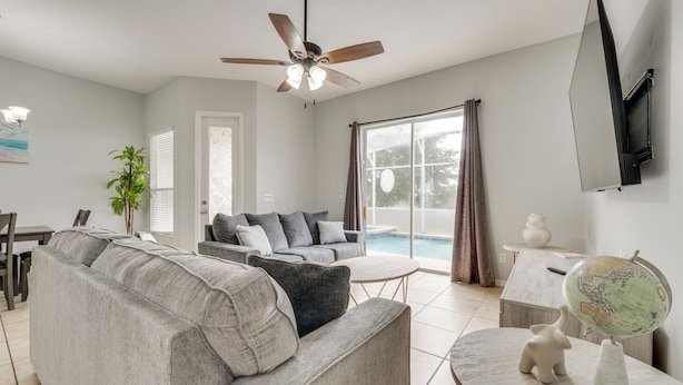 A modern living room with a grey sofa, a coffee table, and a globe on a stand. - Pool & Lanai: Davenport Home 12 Mi to Disney (Davenport)
