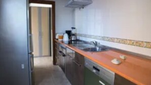 Una cocina con refrigerador de acero inoxidable, un lavamanos y un lavavajillas.
