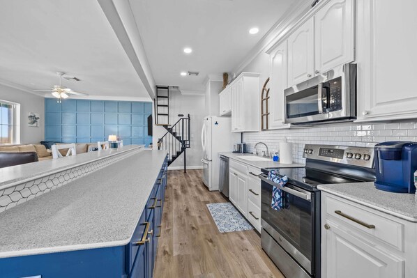 Enjoy a spacious kitchen with a central island, stainless steel appliances, and ample counter space.