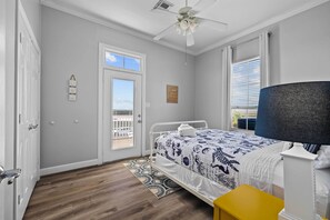 Relax in this stylish room with a single bed, ceiling fan, and large window.