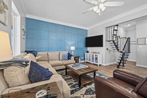 Relax in this stylish living room with a beige sofa, brown armchair, and flat-screen TV.
