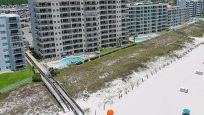 A multi-story hotel with balconies, a swimming pool, and a beach view. - Enclave 803 - is a Family Friendly Beach Front condo! (Orange Beach)