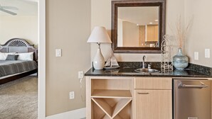 Un bagno d'albergo con lavandino, specchio e un vaso sul ripiano.