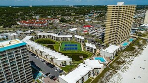 A high-rise hotel with multiple floors, a rooftop pool, and a tennis court. - 2BR/2BA Beach front Sleep8 Balcony-Gated Community (Panama City Beach)