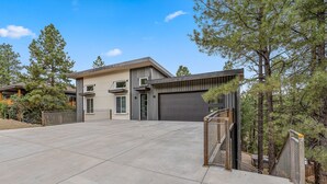 A modern two-story house with a large driveway and a garage.