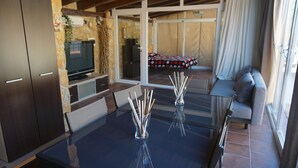 A modern living room with a glass table, dark wooden cabinets, and a sofa. - cozy guest house  (Navas del Rey)