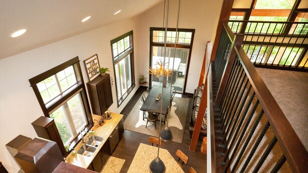 A modern kitchen with a dining area, large windows, and a staircase. - FAll in Suncadia! Walk to the new Suncadia social & Golf! Hot Tub and Games! (Cle Elum)
