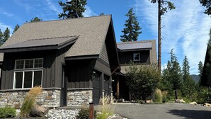 A modern two-story house with a stone foundation and dark wooden exterior. - FAll in Suncadia! Walk to the new Suncadia social & Golf! Hot Tub and Games! (Cle Elum)