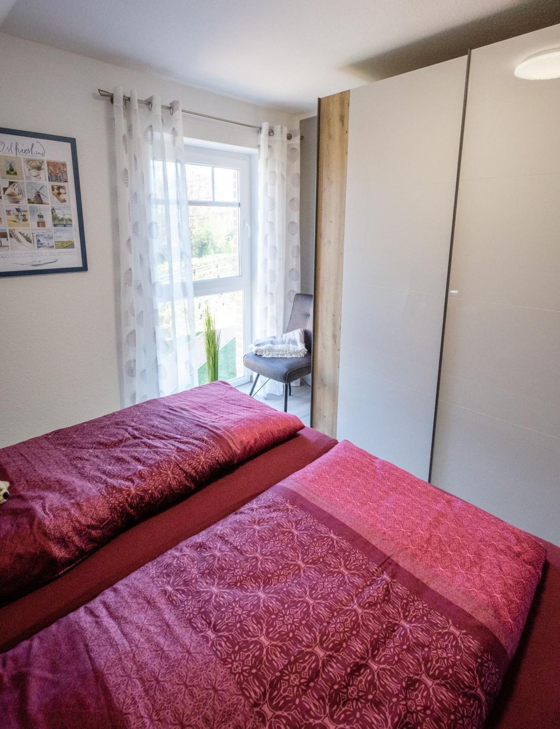 A bedroom with two beds, a desk, and a wardrobe.