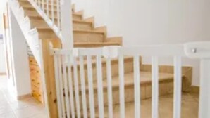 Una escalera con barandillas blancas y peldaños de madera.