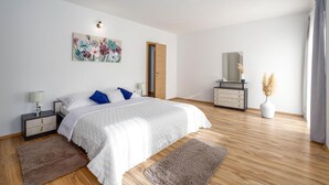 A bedroom with a bed, nightstands, a dresser, a mirror, and a painting. - Stunning home in Tugare (Tugare)