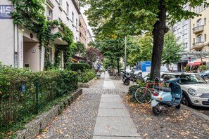 Stroll through a charming urban street lined with mature trees and a mix of architectural styles.