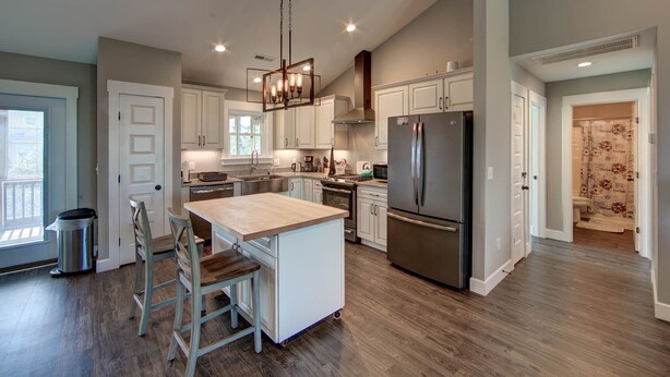 A spacious kitchen with a central island, stainless steel appliances, and a chandelier. - New construction home short walk to the beach! (Avon)