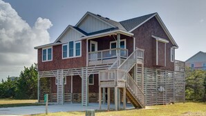 A two-story house with a balcony and a wooden deck. - New construction home short walk to the beach! (Avon)