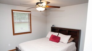 A bedroom with a bed, a ceiling fan, a window with blinds, and a nightstand. - 2 Bedroom, 1 Bathroom Convenient Green Bay Getaway (Bellevue)