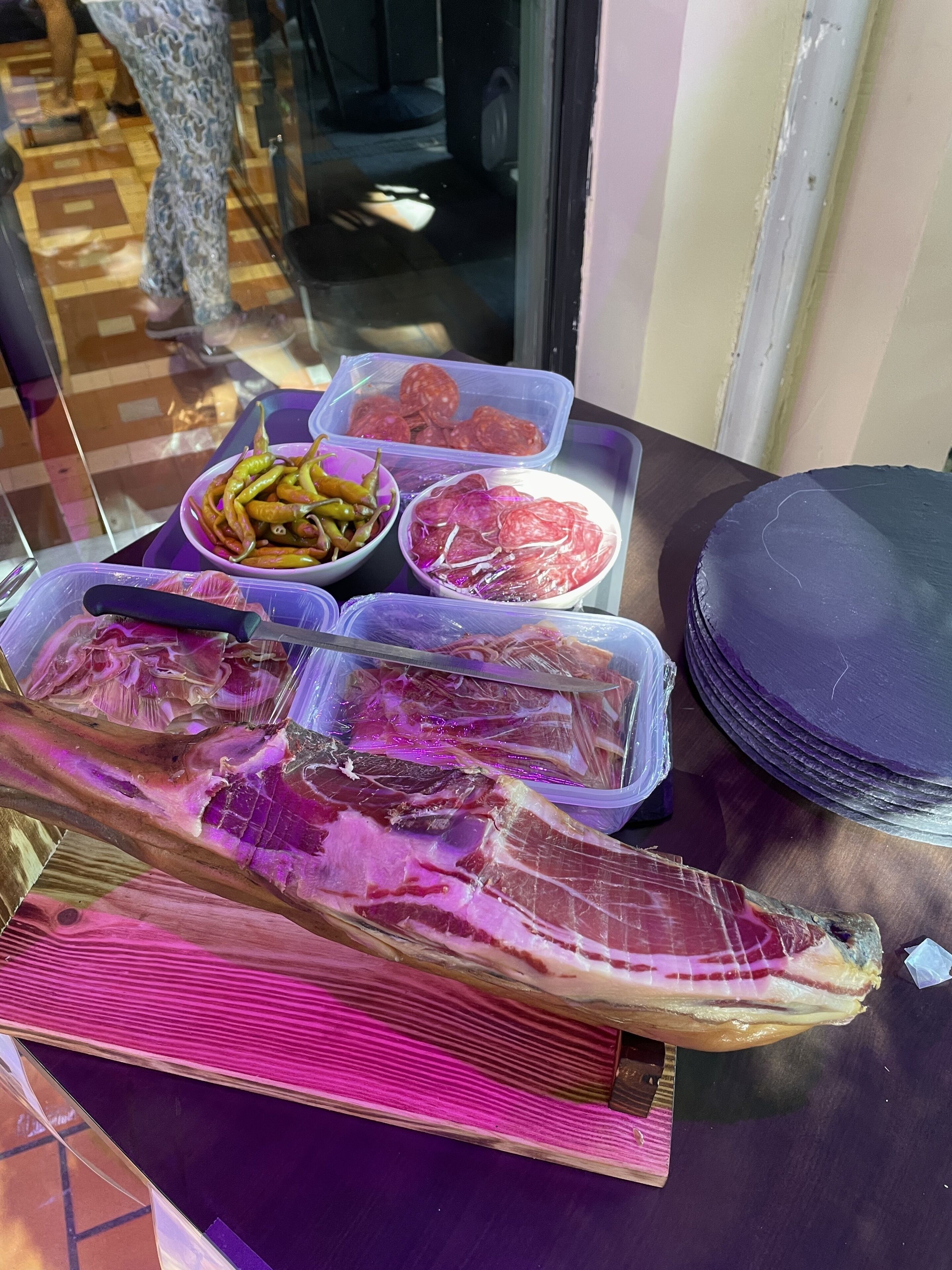 A table with various food items including sliced meats and vegetables.